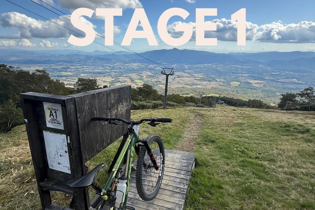 The stage one start on the Annupuri summit, a bike leaning against the section A1 course board above the Niseko valley