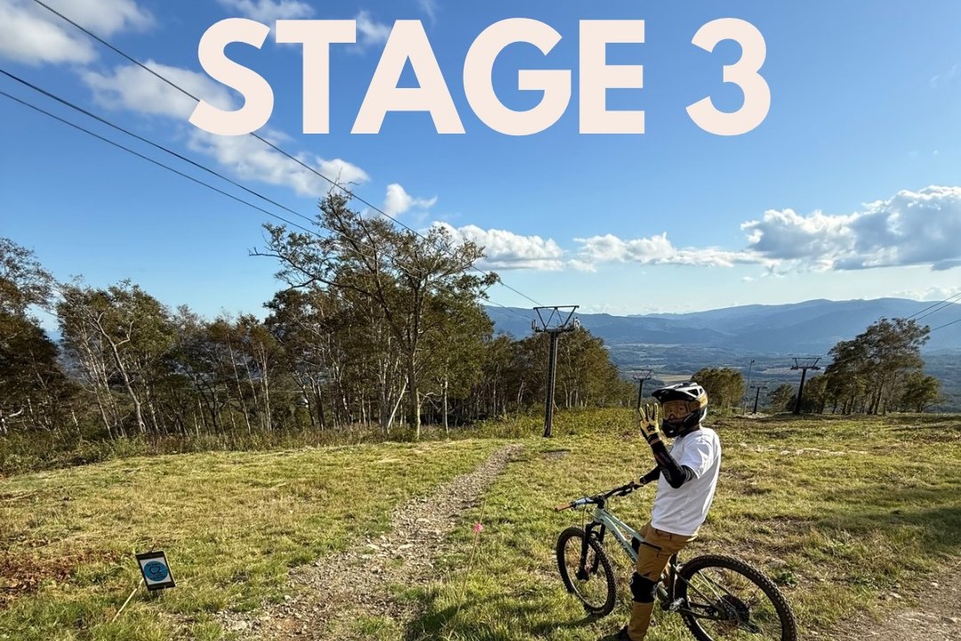 A rider waving at the stage three start, the trail running down towards the treeline