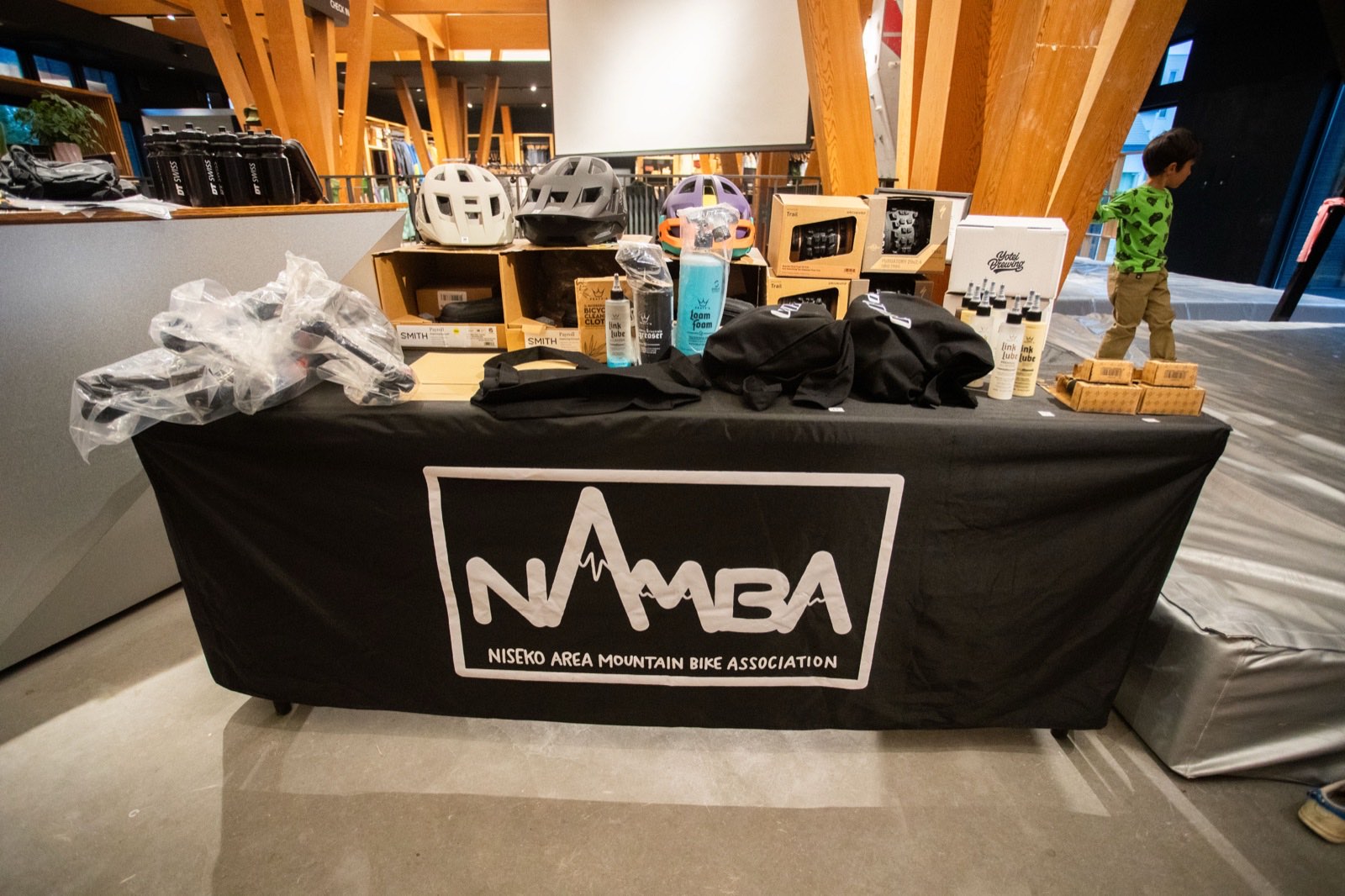 NAMBAのテーブルに並んだ抽選会の賞品。ヘルメット、サスペンションフォーク、バイクケア用品、アパレルなど