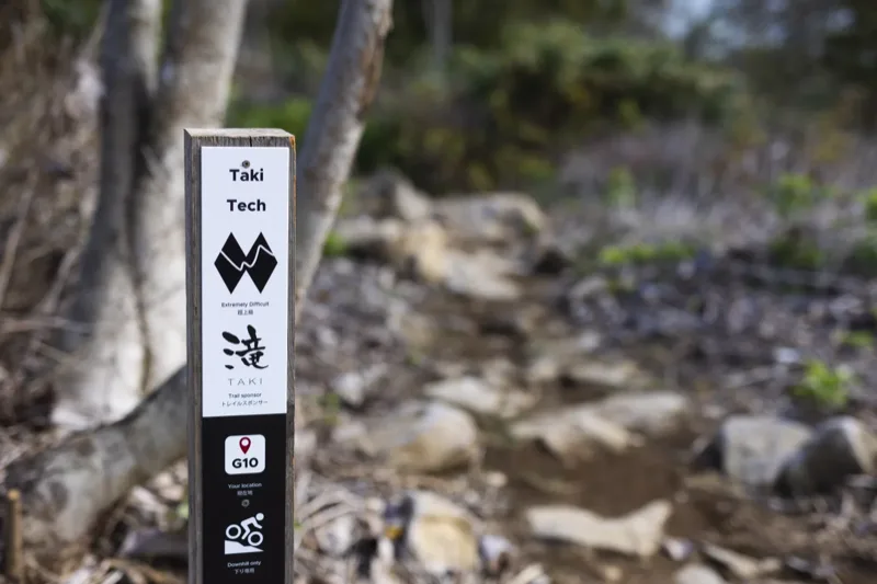 Trail marker sign at Twin Peaks showing sponsor logo and trail information