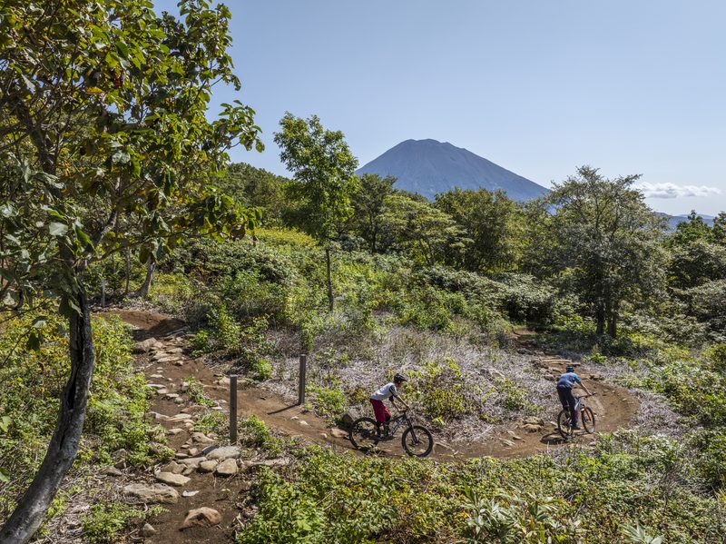 Riders on a Niseko trail with Mt Yotei in the background