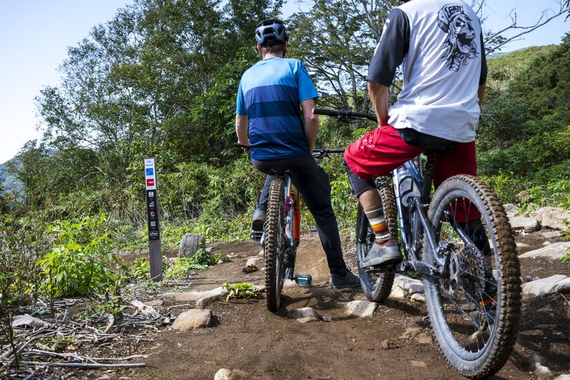 Riders pausing at a trail signpost in Twin Peaks Bike Park
