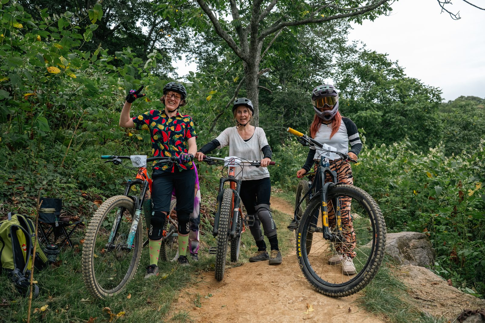 出走前、トレイルでバイクとともに立つAngharad Mortiboy、Stephanie Watanabe、Sachi Matsuzawa。Angharadはピースサインをしている