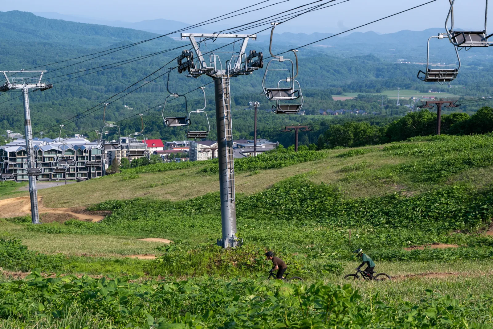 Grand Hirafu chairlift descending toward Hirafu Village with riders on the lower trails