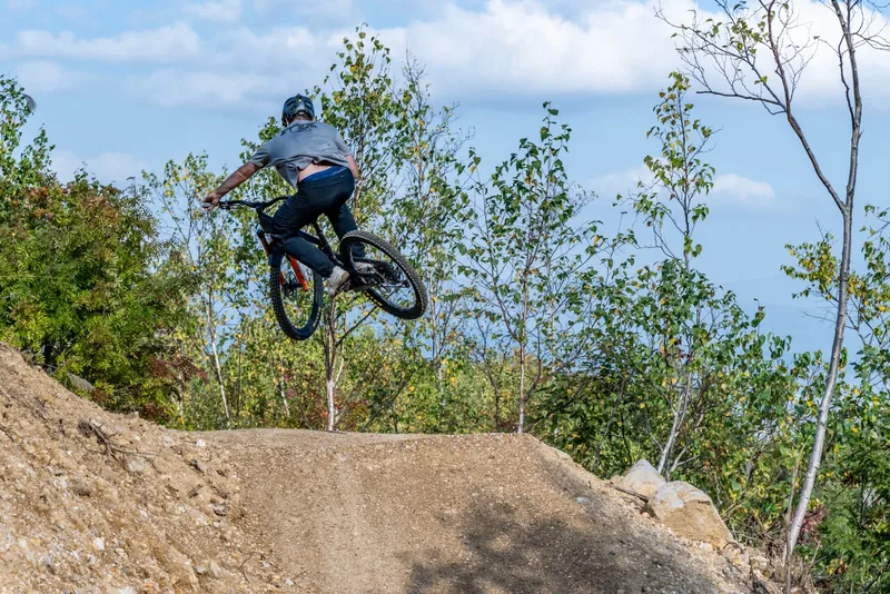 Rider airborne off a dirt jump at Hanazono Mountain Bike Park