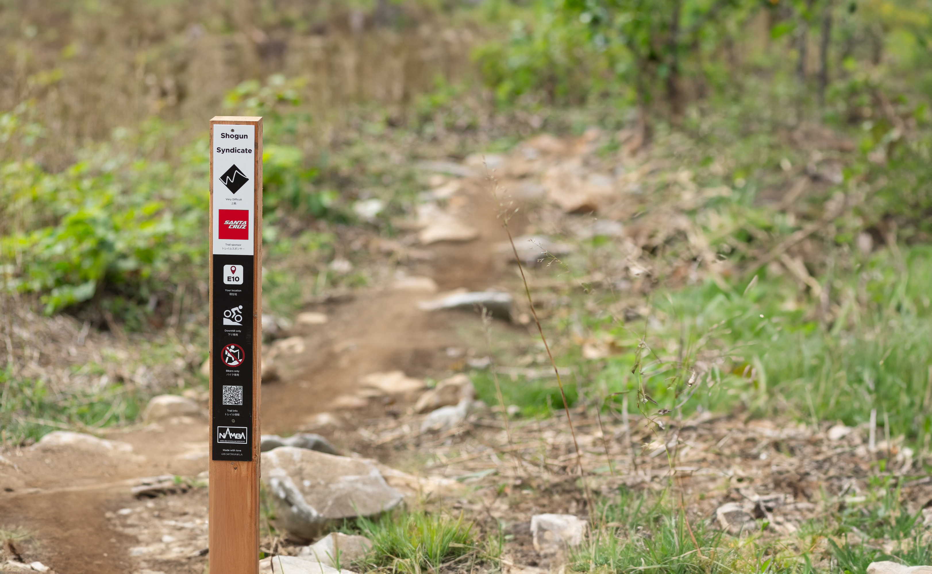 Unified NAMBA trail sign at Twin Peaks Bike Park showing difficulty, direction, and location markers